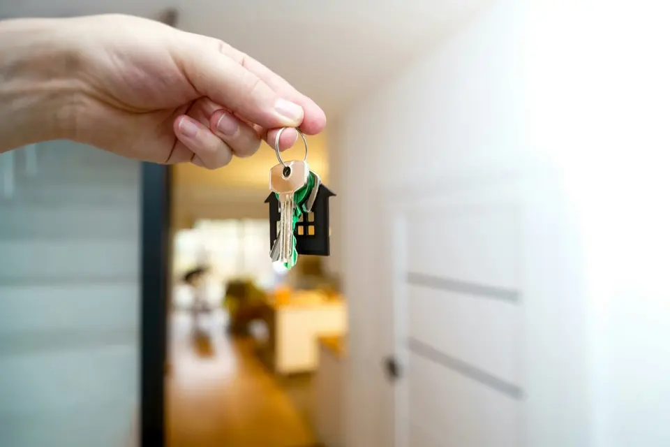 House keys with home-shaped keychain — selling mortgage notes and real estate